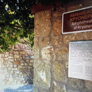 שלט נירוסטה ביוונית, אנגלית ועברית בכפר ביוון